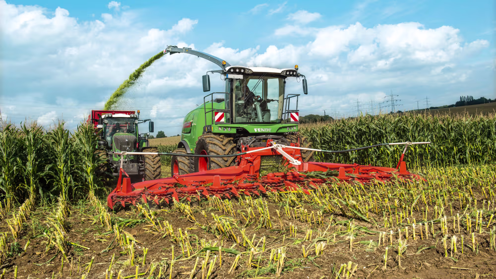 Traktor mit Bodenfräse führt eine Bodenbearbeitung durch im Maisfeld
