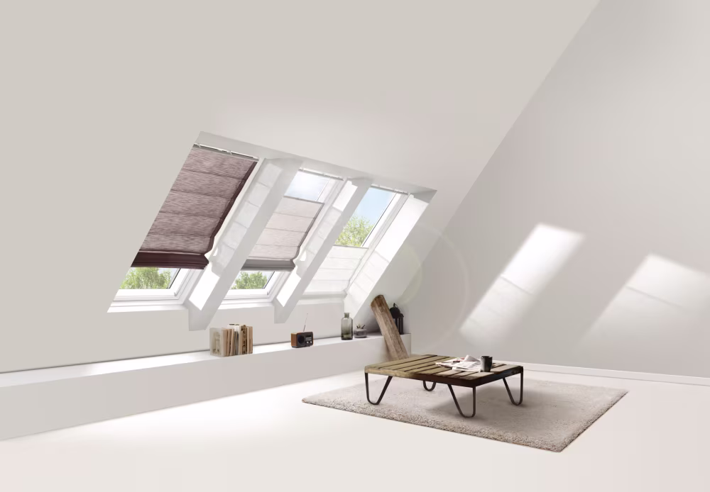 Drei Dachfenster mit braunen Rollos