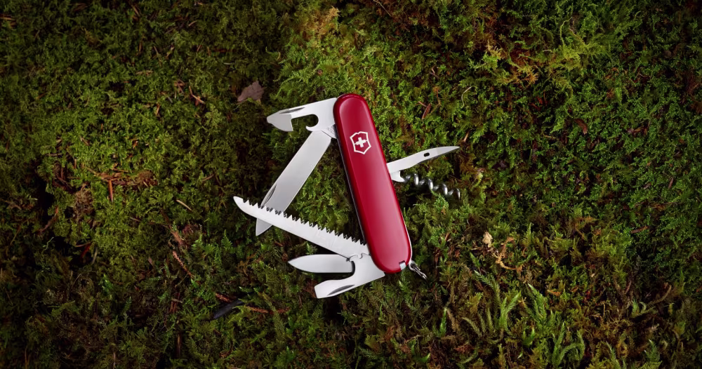Ein rotes Multitool liegt auf Moos