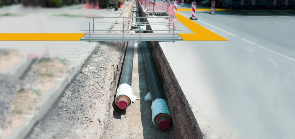 Eine Metallbrücke führt über eine Baustellen-Grube