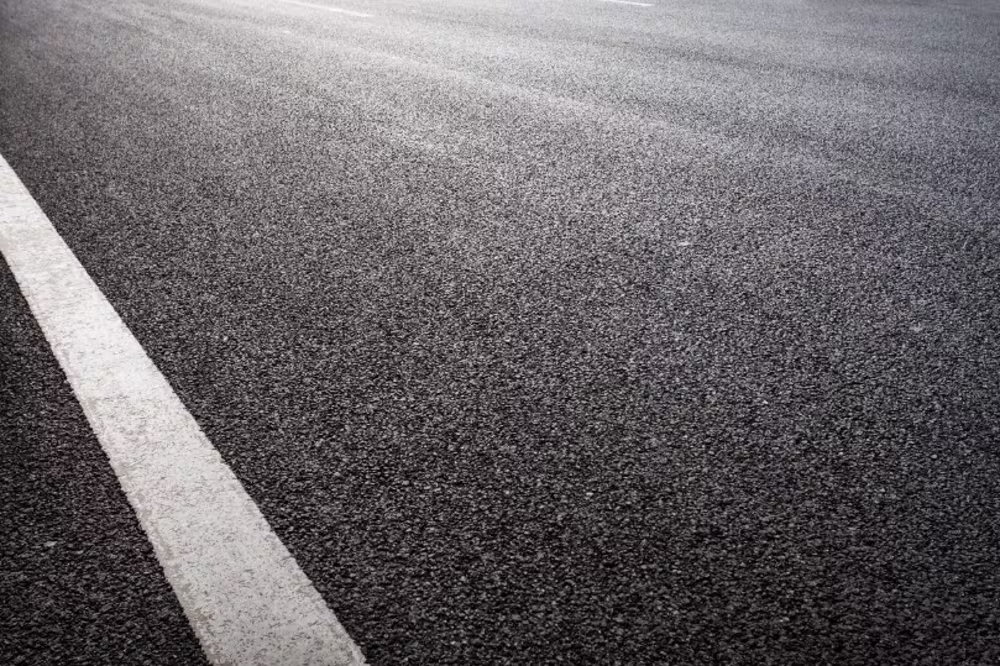 Asphalt mit Fahrbanmarkierung
