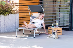 Frau mit Hund auf Terrasse