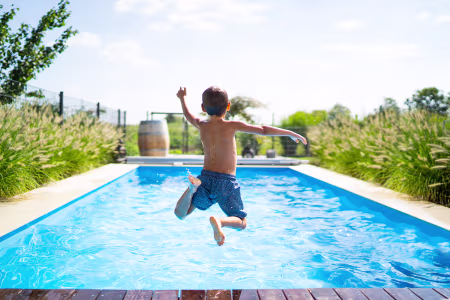 Kind springt in Pool