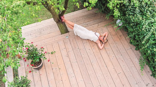 Frau liegt auf Holzterrasse