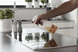Lifestyle: Anwendung von Ballistol Kamofix Reiniger auf Ceranfeld in moderner Küche
