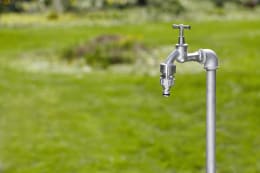 Produktbild: GARDENA Premium Hahnverbinder mit Gewinde, montiert an Wasserhahn im Garten