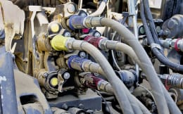 Produktbild: Kennfixx® Hydraulik-Handgriffe in verschiedenen Farben an Hydraulikschläuchen montiert