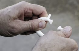 Produktbild: Weißer Saugentwöhner mit Stacheln für Rinder, in Hand gehalten