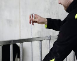 Lifestyle: Person montiert modulares Zaunteil für Kälberaufstallung mit Steckverbindung