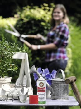 Lifestyle: Ballistol Universalöl-Sprühdose neben Gartenwerkzeugen auf Tisch im Garten