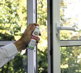 Produktbild: Ballistol Universalöl-Sprühdose bei der Anwendung an einem Fensterscharnier