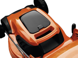 Produktbild: Husqvarna® Akku-Rasenmäher in Orange mit schwarzen Rädern, Draufsicht auf Gehäuse und Griff