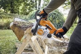 Lifestyle: Person sägt mit STIHL Benzin-Kettensäge MS 162 einen Baumstamm im Garten