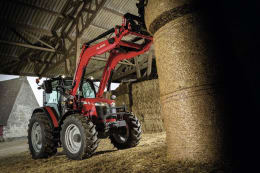 Lifestyle: Massey Ferguson Traktor MF 5709 M mit Frontlader beim Heben von Heuballen in einer Scheune