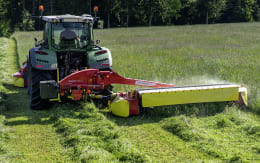 Lifestyle: Pöttinger Scheibenmähwerk NovaCat im Einsatz auf einer Wiese, am Heck eines Traktors montiert