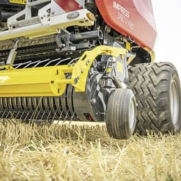 Produktbild: Pöttinger Rundballenpresse Impress mit gelber Aufnahmeeinheit und roter Presskammer auf dem Feld