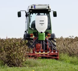 Produktbild: LEHNER® Düngerstreuer Vinero® 110 mit weißem Behälter, montiert auf grünem Traktor im Einsatz