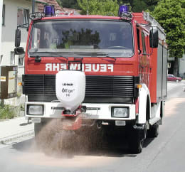 Produktbild: LEHNER® Ölbinderstreuer Öl Tiger® montiert an Feuerwehrfahrzeug beim Streuen von Ölbindemittel