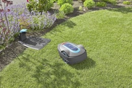 Produktbild: GARDENA Mähroboter smart SILENO city auf Rasen mit Ladestation im Hintergrund