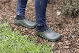 Lifestyle: Person trägt olivgrüne nora Gartenschuhe Comfy im Garten