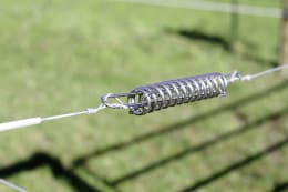 Lifestyle: Spannfeder aus Metall verzinkt an gespanntem Draht im Außenbereich montiert