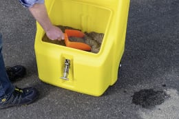 Produktbild: Orange Handschaufel aus Kunststoff im Einsatz mit Streugut