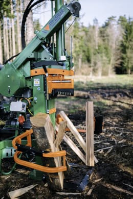 Produktbild: Posch Holzspalter HydroCombi in grün-orange beim Spalten von Holzscheiten im Außenbereich