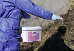 Lifestyle: Anwendung von Insektengranulat gegen Fliegenlarven im Tierstall mit Schutzkleidung