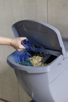 Lifestyle: Futterbox mit Deckel wird mit Messbecher befüllt