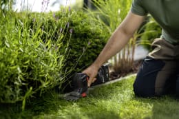 Lifestyle: Person schneidet Rasenkante mit Husqvarna® Akku-Grasschere Aspire® S20-P4A