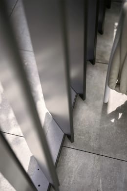 Lifestyle: Detailansicht der Lamellenseitenwand für Pergola in quarzgrau-metallic mit Sonnenlichteinfall