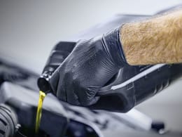 Produktbild: Schwarzer Nitril-Einmalhandschuh mit strukturierter Grip-Oberfläche an Hand