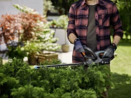 Lifestyle: Mann schneidet Hecke im Garten mit GARDENA Akku-Heckenschere EasyCut 45