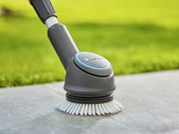 Produktbild: GARDENA Akku-Multi-Reiniger AquaBrush mit rotierender Bürste auf Steinboden