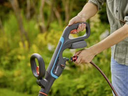 Lifestyle: Person hält GARDENA Akku-Multi-Reiniger AquaBrush bei der Gartenarbeit