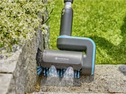 Lifestyle: GARDENA Akku-Multi-Reiniger beim Reinigen von Steinplatten mit rotierenden Bürsten und Wasser