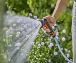 Lifestyle: Person bewässert Blumen im Garten mit GARDENA Multifunktionsbrause Classic