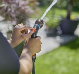 Lifestyle: Person stellt Sprühmuster an GARDENA Multifunktionsbrause Classic Compact im Garten ein