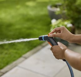 Produktbild: GARDENA Reinigungsspritze Classic mit orangem Bedienknopf in Hand gehalten