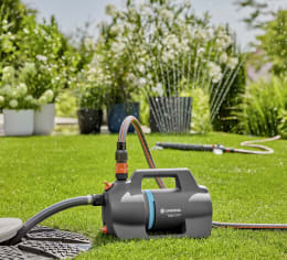 Produktbild: GARDENA Gartenpumpe 5000 Silent mit Sauggarnitur auf Rasen im Garten