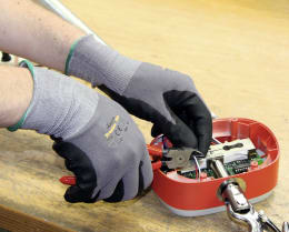Lifestyle: Hände mit Arbeitshandschuhen bei Feinmontage an Elektronikgerät