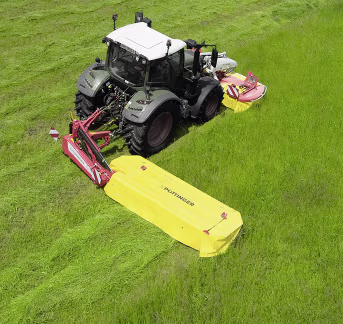 Lifestyle: Traktor mit Pöttinger NovaCat Scheibenmähwerk beim Mähen auf grüner Wiese
