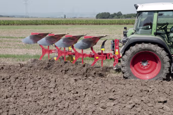 Lifestyle: Pöttinger Pflug Servo 25 im Einsatz auf dem Feld, gezogen von einem Traktor