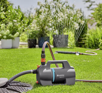 Produktbild: GARDENA Gartenpumpe 5000 Silent mit Sauggarnitur auf Rasen im Garten