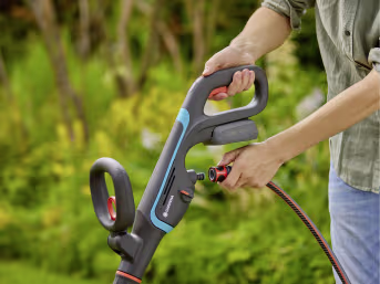 Lifestyle: Person hält GARDENA Akku-Multi-Reiniger AquaBrush bei der Gartenarbeit