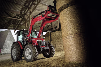 Lifestyle: Massey Ferguson Traktor MF 5709 M mit Frontlader beim Heben von Heuballen in einer Scheune