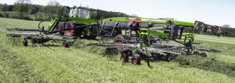 Lifestyle: Fendt Schwader Former im Einsatz auf einer Wiese, gezogen von einem grünen Traktor