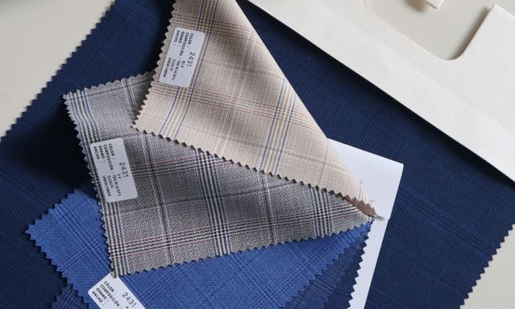 Premium check suiting swatches in beige, grey and blue on navy cloth