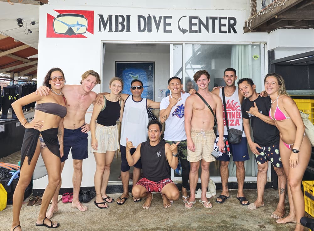 Divers practising reef-safe buoyancy over the coral around Malapascua