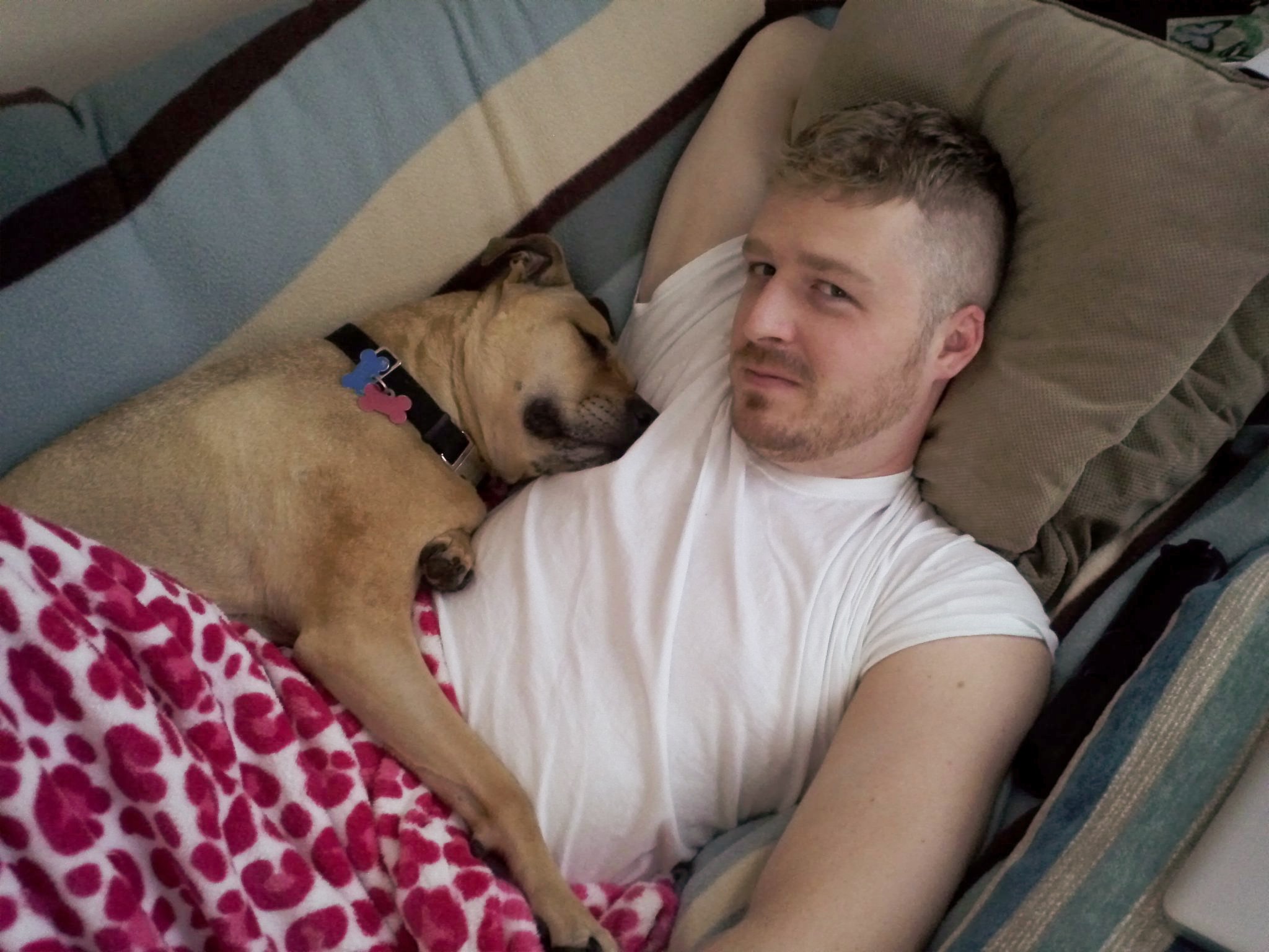 Adam on his mother's couch with her dog